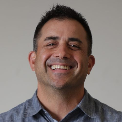 Man smiling with a neutral background