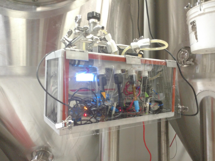 Small electronic device with visible wiring and components on a metallic background