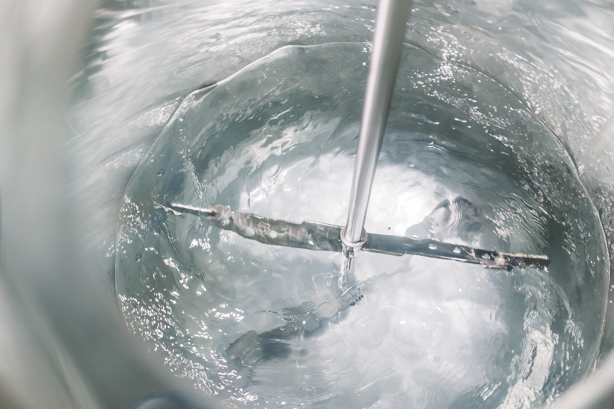 Metallic stirrer inside a container with a reflective surface
