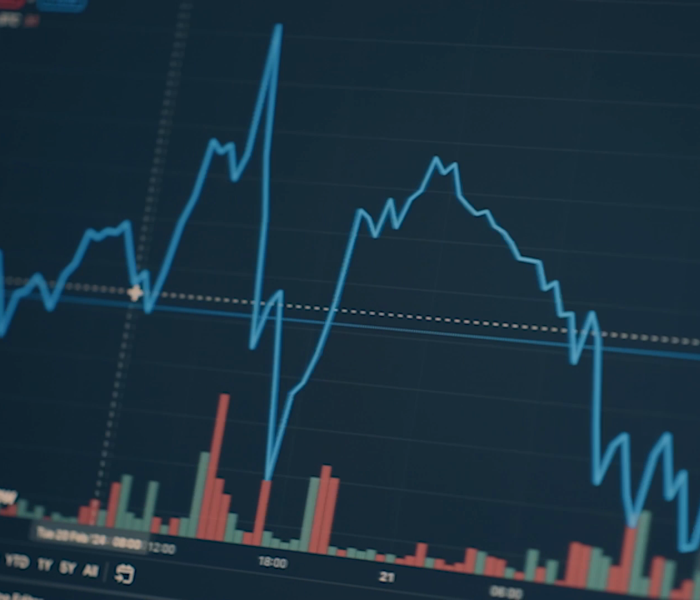 Stock market graph with blue line and red and green bars on a dark background